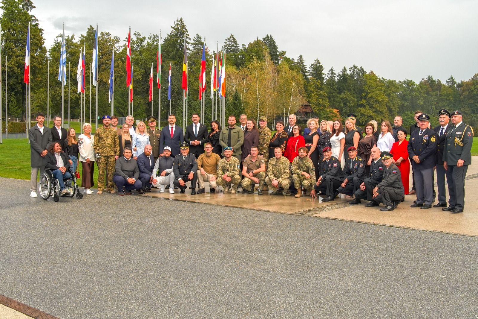 The Ukrainian delegation, veterans and partners in front of the flag line at Brdo, Slovenia, October 2026