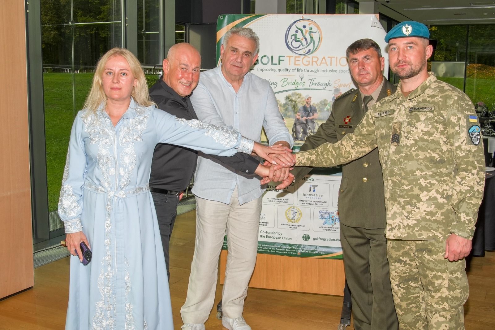 Partners join hands in front of the Golftegration banner